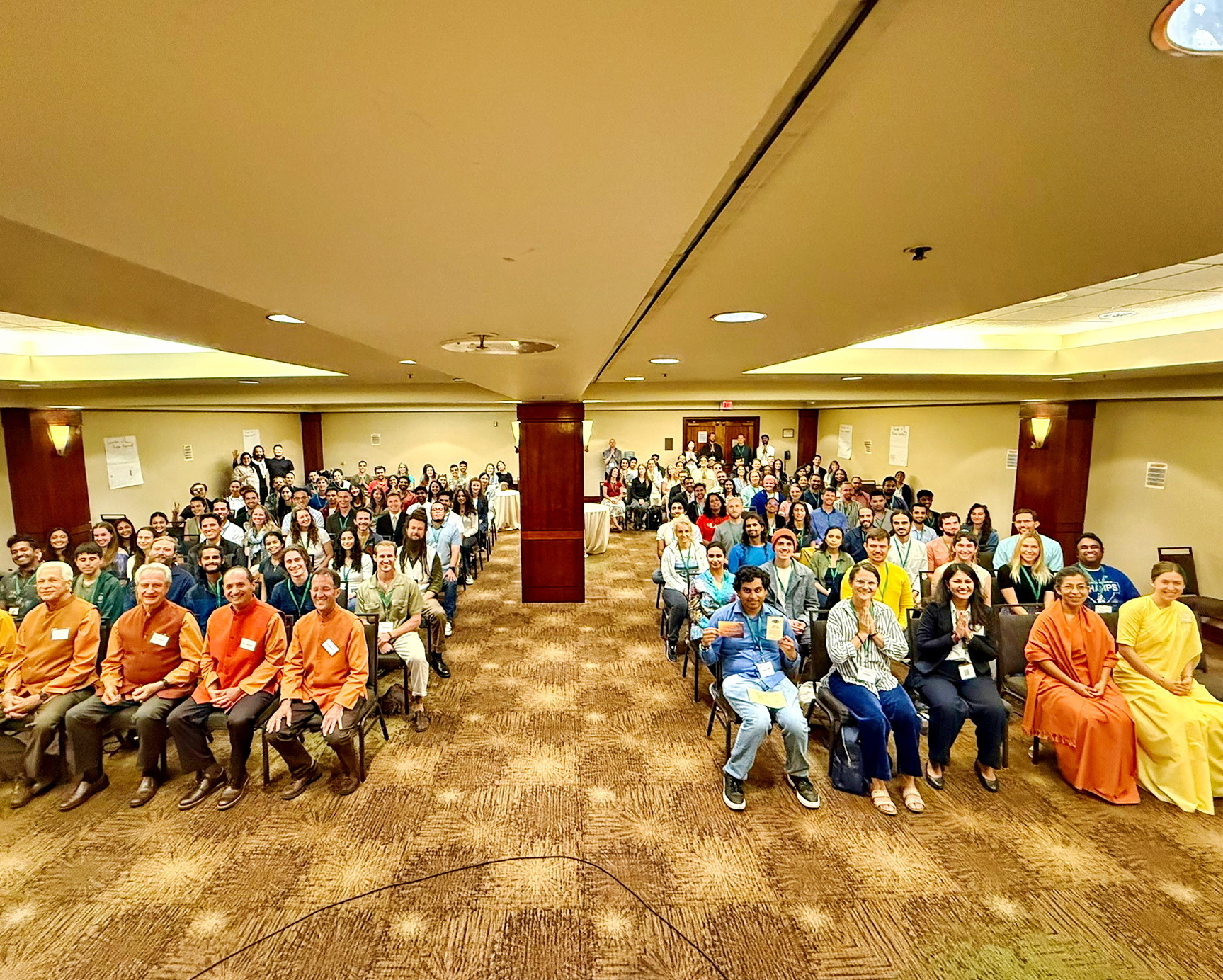 A large gathering of SRF young adults participate in an interactive class with SRF monks and nuns.