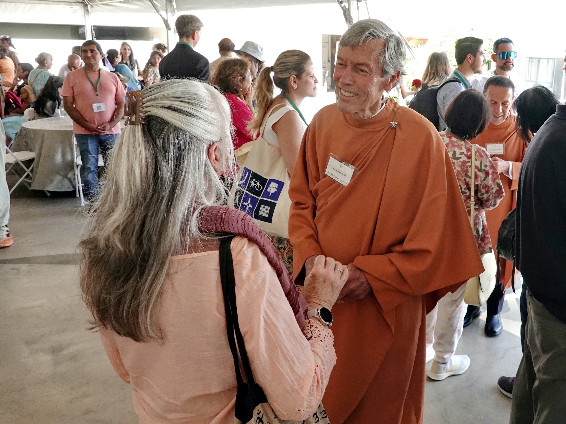 Brother Amritananda welcomes an SRF member to Convocation.