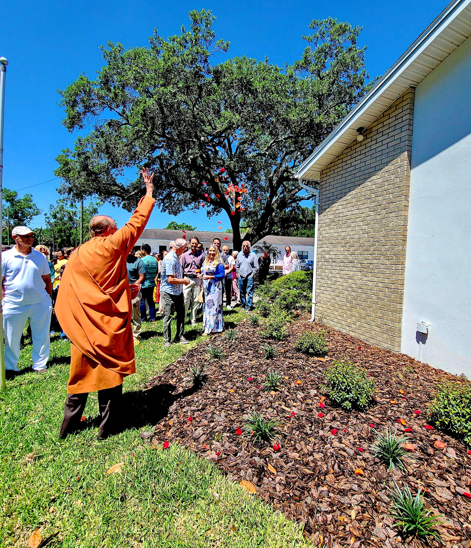 Bro. Prafullananda helps distribute rose petals around the grounds of Tampa Meditation Group's new facility.