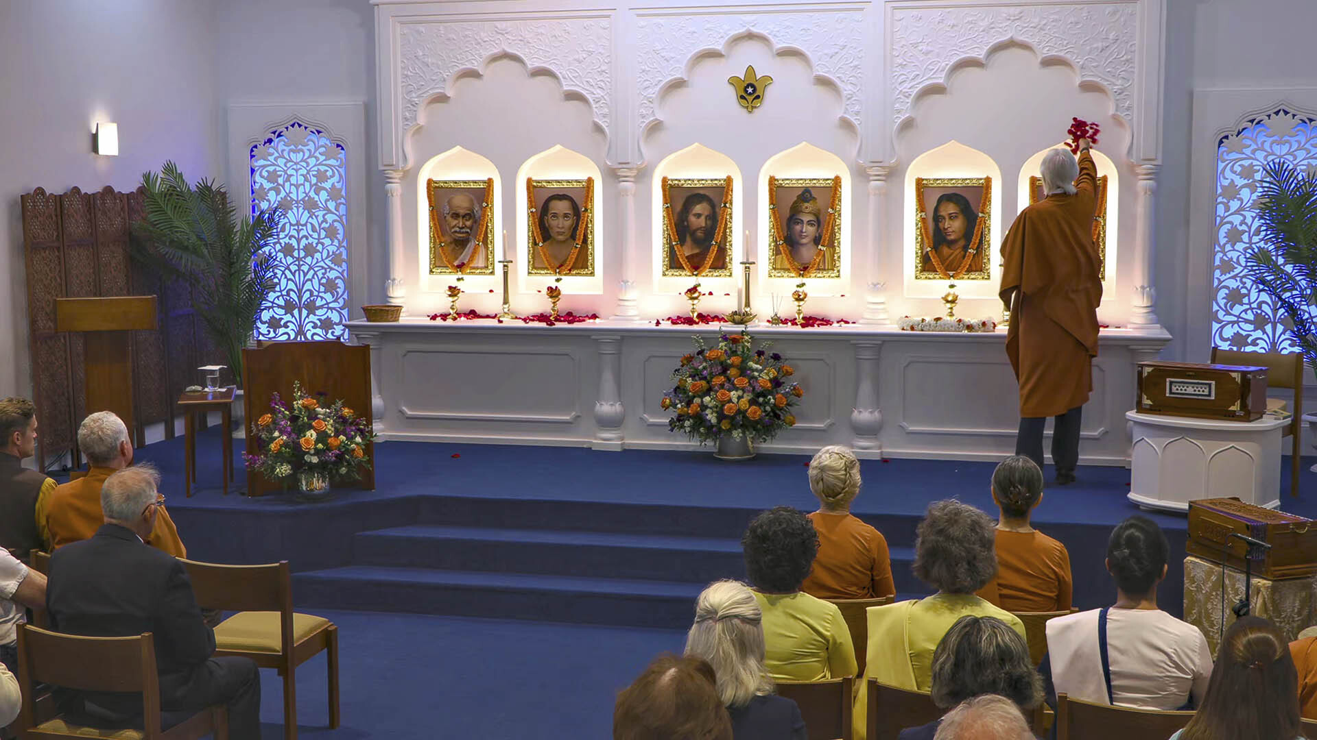 At the start of the inauguration, Brother Chidananda offers rose petals at the altar in the meditation hall's chapel.