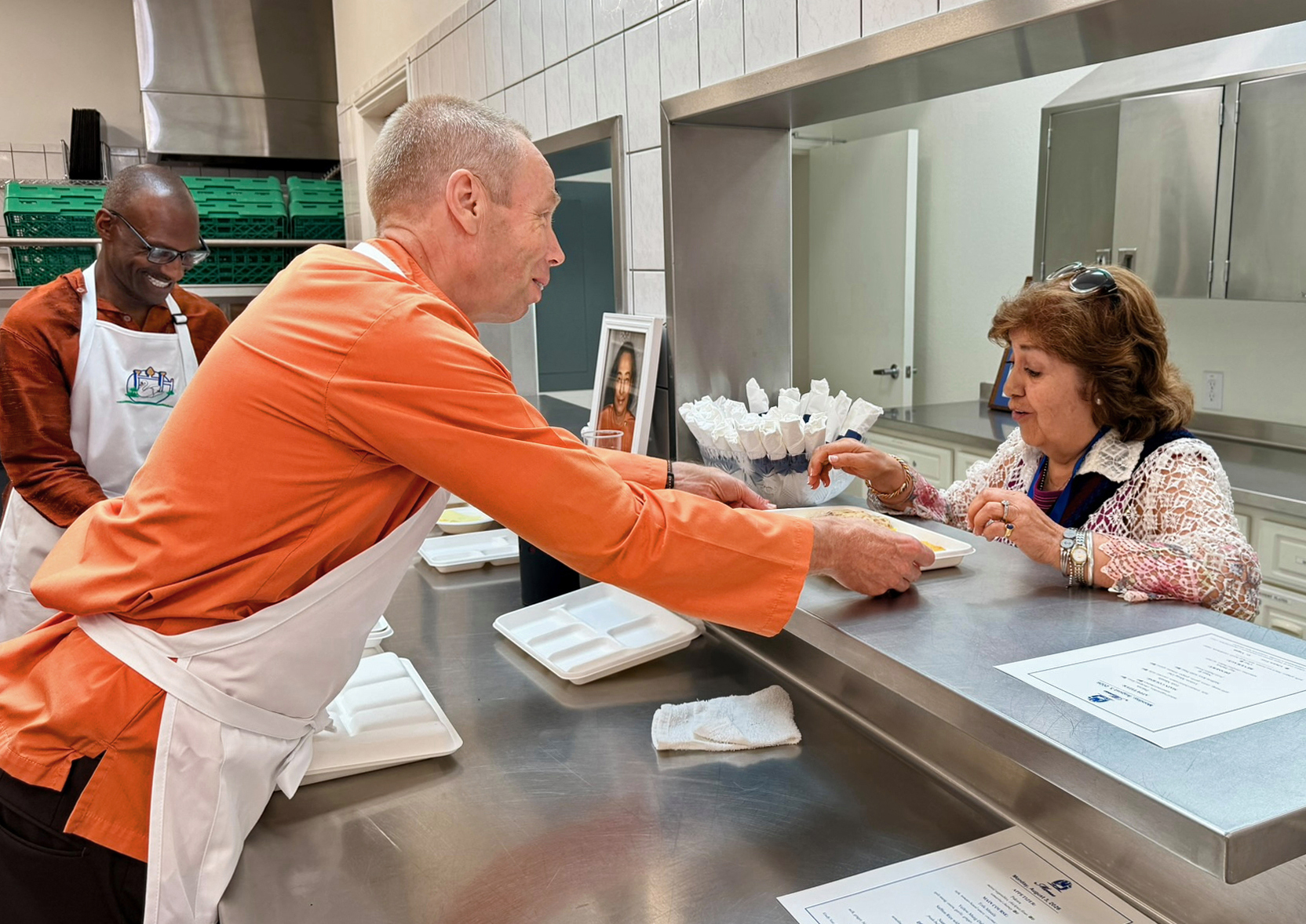 Brother Vidurananda warmly serves a devotee.