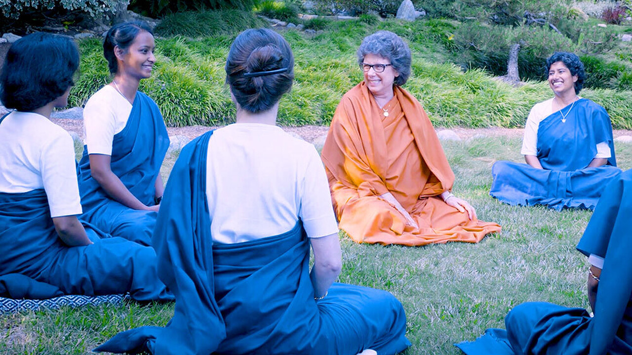 Nuns sitting on grass talking
