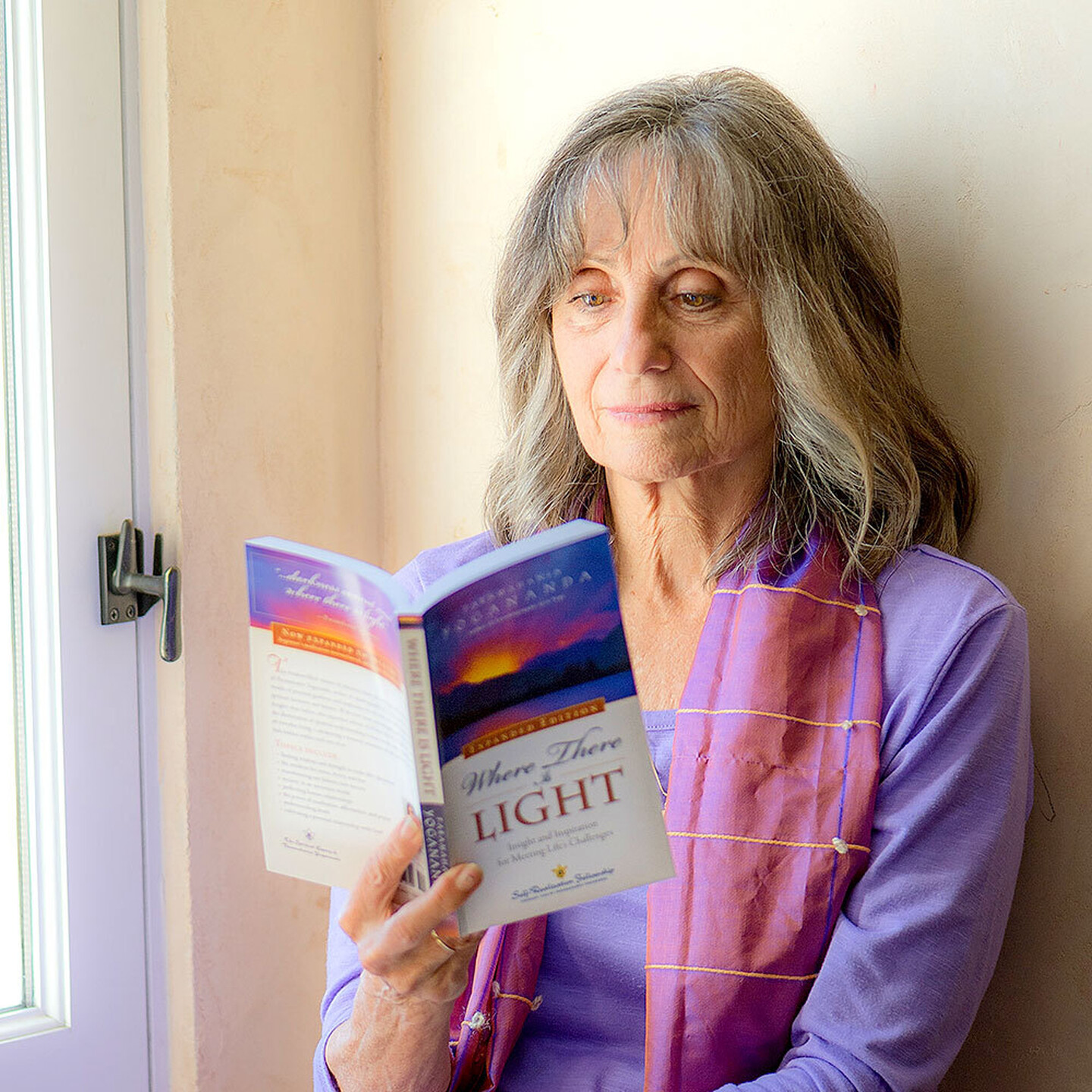 Devotee reading Where There Is Light book