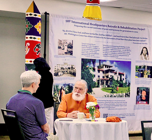 Brother sitting with devotee talking at table